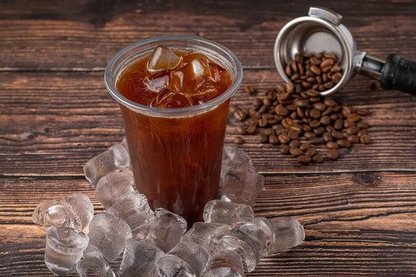 Kahve dükkanındaki ahşap bir masaya buz küplü buzlu Americano kahvesi. Bir bardak kahvenin üst görüntüsü..