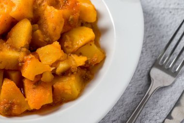 Kıyma ve patates tabağı beyaz porselen tabakta taş masada.