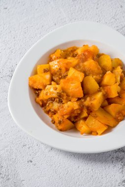 Kıyma ve patates tabağı beyaz porselen tabakta taş masada.