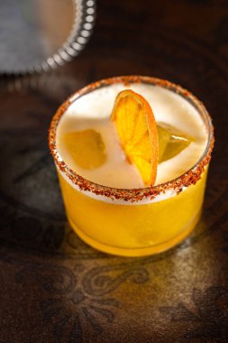 Ahşap masada koyu bir arka planda lüks bir kokteyl.