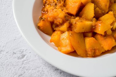 Kıyma ve patates tabağı beyaz porselen tabakta taş masada.