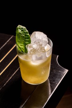 Ahşap masada koyu bir arka planda lüks bir kokteyl.