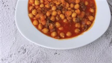 Beyaz bir porselen tabakta kıymalı nohut yahnisi.