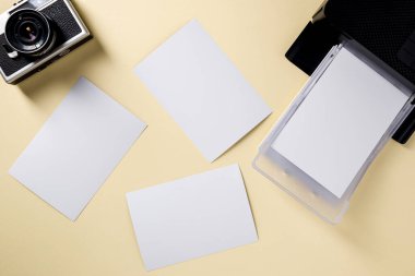 Retro kameranın üst görünümü, boş fotoğraf kağıtları ve mobil fotoğraf yazıcısı