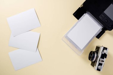 Retro kameranın üst görünümü, boş fotoğraf kağıtları ve mobil fotoğraf yazıcısı