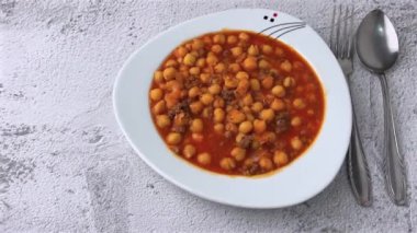 Beyaz bir porselen tabakta kıymalı nohut yahnisi.