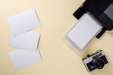 Retro kameranın üst görünümü, boş fotoğraf kağıtları ve mobil fotoğraf yazıcısı