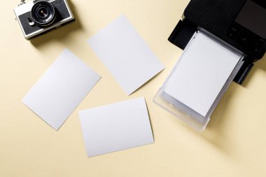Retro kameranın üst görünümü, boş fotoğraf kağıtları ve mobil fotoğraf yazıcısı