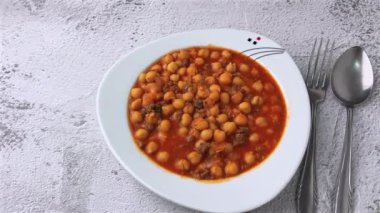 Beyaz bir porselen tabakta kıymalı nohut yahnisi.