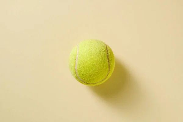 Top view of tennis ball on yellow background