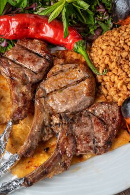 Güzel bir restoranda çeşitli sebzelerle kuzu pirzolası.