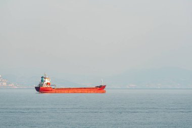 Orange general cargo ship anchored off the coast of Alanya, Antalya clipart