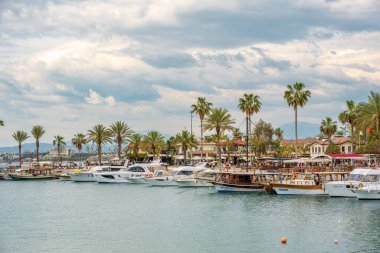 Taraf, Manavgat, Türkiye - 9 Nisan 2024: Türkiye 'nin eşsiz ve tarihi tatil beldelerinden biri olan Side' daki gezi tekneleri ve kasaba meydanı
