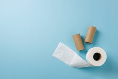 Mavi arkaplanda tuvalet kağıdı rulosunun üst görünümü