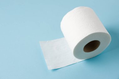 Mavi arkaplanda tuvalet kağıdı rulosunun üst görünümü