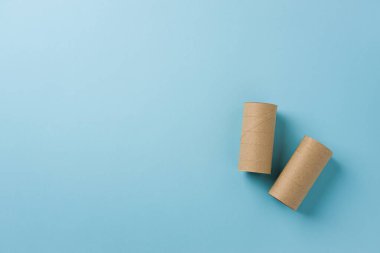 Top view of two empty toilet paper rolls on blue background