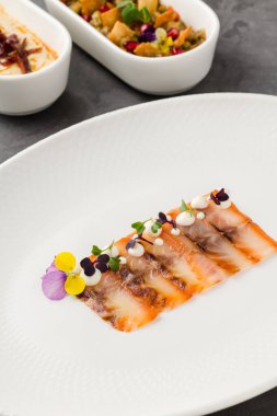 Füme balık pastırması ya da beyaz porselen tabakta domuz pastırması.