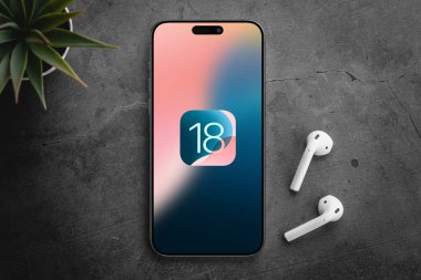 Antalya, Türkiye - 11 Haziran 2024: iPhone 15 Pro ekran ve yeni iOS 18 logosu, Apple 'ın akıllı telefonları için bir sonraki işletim sistemi piyasaya sürülecek