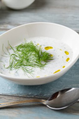 Tahta masadaki beyaz porselen tabakta Türk Kakası veya Tzatziki (kakiki)