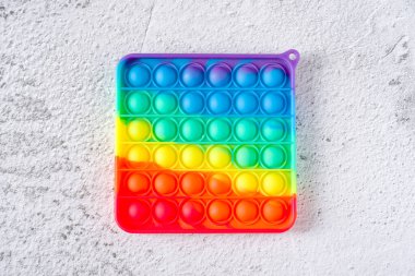 Gökkuşağı anti-stres oyuncağının üst görüntüsü. Duyusal oyuncak. Onu taş zemine yerleştir.