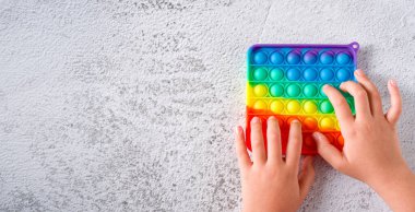 Gökkuşağı anti-stres oyuncağının üst görüntüsü. Duyusal oyuncak. Onu taş zemine yerleştir.