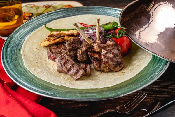 Ahşap masada adana kebabı, ızgara tavuk ve kuzu tandırından oluşan karışık Türk ızgarası.