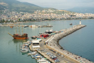 Antalya, Türkiye - 12 Nisan 2024: Antalya 'nın Kızıl Kule' deki turistik bölgelerinden biri olan Alanya marinasının ve yürüyüş yolunun görüntüsü