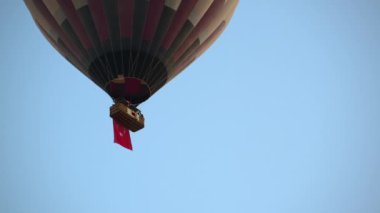 Mavi gökyüzünde yükselmek için yanan sıcak hava balonu