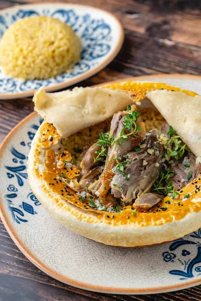 stock image Lamb shank with bulgur pilaf and dough-covered top from traditional Turkish cuisine