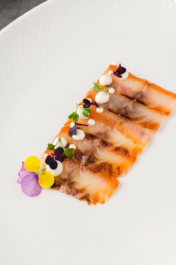 Füme balık pastırması ya da beyaz porselen tabakta domuz pastırması.