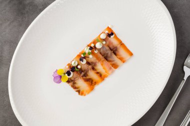 Füme balık pastırması ya da beyaz porselen tabakta domuz pastırması.