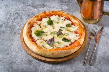 Dört peynirli Napoli pizzası. Taş masada tahta kesme tahtası.