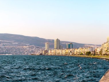 Kordon Caddesi manzarası, feribot iskelesi ve İzmir Pasaport Bölgesi 'ndeki denizden yükseltilmiş binalar.