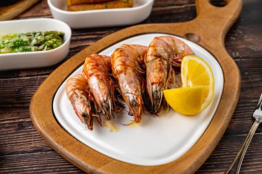 Kırmızı karides ya da beyaz tabakta yeşil ve domatesli kaplan karidesi. Kaplan karidesi