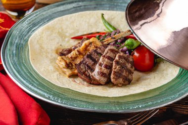 Ahşap masada adana kebabı, ızgara tavuk ve kuzu tandırından oluşan karışık Türk ızgarası.