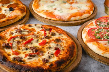 Gri taş masadaki çeşitli Napoli pizzalarının üst görüntüsü