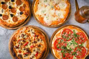 Gri taş masadaki çeşitli Napoli pizzalarının üst görüntüsü