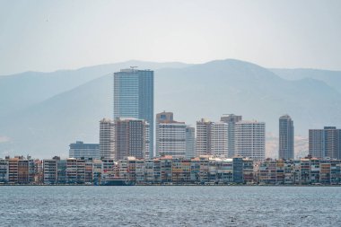 İzmir, Türkiye - 3 Temmuz 2024: İzmir Pasaport Bölgesi 'nde Kordon Caddesi, feribot iskelesi ve yüksek binaların manzarası