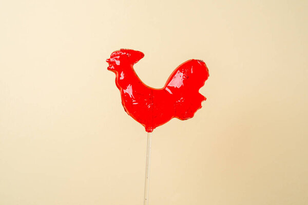 Red candy rooster or cock on a stick, traditional Russian lollipop