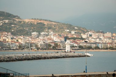 Antalya, Türkiye - 12 Nisan 2024: Antalya 'nın Kızıl Kule' deki turistik bölgelerinden biri olan Alanya marinasının ve yürüyüş yolunun görüntüsü