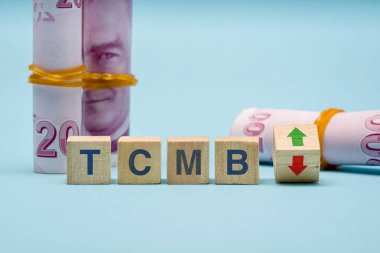 TCMB (Türkiye Cumhuriyet Merkez Bankası) ve yukarıdan aşağıya oklu tahta küpler. Enflasyonu azaltmak için TCMB faiz oranı artışı kavramı