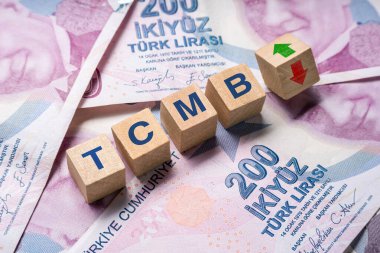 200 TL üzerinde TCMB (Türkiye Cumhuriyet Merkez Bankası) ve yukarı-aşağı okları olan tahta küpleri. Enflasyonu azaltmak için TCMB faiz oranı artışı kavramı