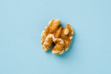 Mavi arkaplanda yarım ceviz çekirdeğinin üst görünümü