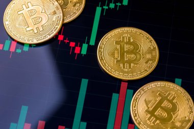 Bitcoin ve kripto para yatırım konsepti. Bitcoin 'in yükseliş ve düşüş grafiğinin önünde duran Altın Bitcoin kripto para sembolü
