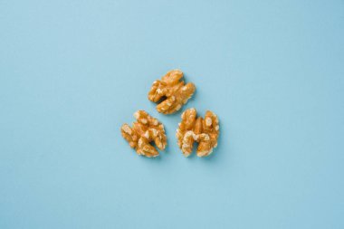 Mavi arkaplanda yarım ceviz çekirdeğinin üst görünümü