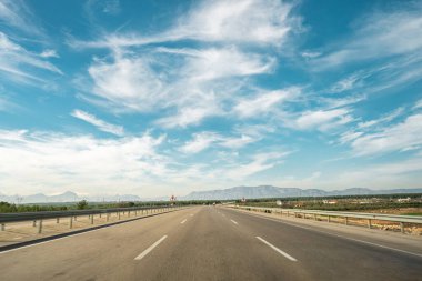 Güneşli bir günde ilerleyen üç şeritli otoyol