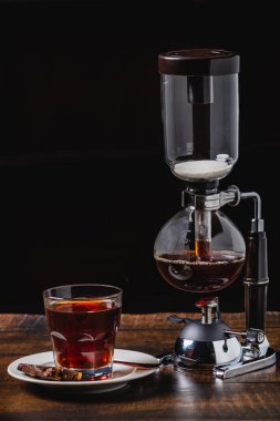 Kahve makinası ya da elektrikli süpürge ve yanında taze demlenmiş kahve.