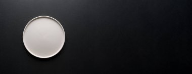 Siyah zemin üzerinde boş seramik beyaz plakanın üst görünümü