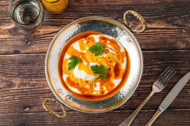 Haşlanmış yumurta Türkçe adı cilbir, klasik Türk yemeği, metal tabakta.