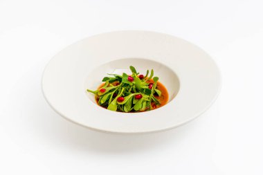 Beyaz porselen tabakta zeytinyağı ve nar salatası.